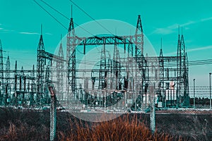 High voltage Electrical substation with steel frames, insulators and electricity transmission power lines and blue sky background