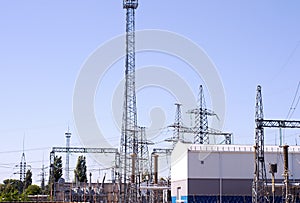 High voltage electrical substation with transformers and electric towers.