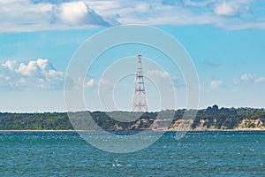 High voltage electrical tower next to the sea photo