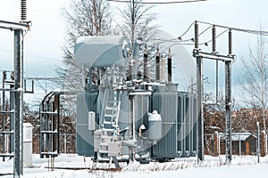 High voltage electrical transformer at a power plant in winter