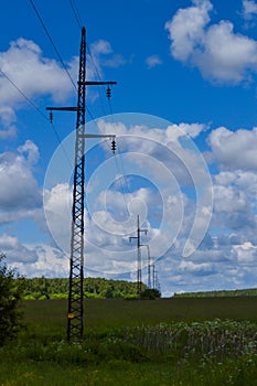 High voltage electrical transmission towers and power lines on field