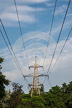 high-voltage electricity line, against the background of the sky, green trees