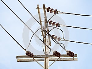 High voltage electricity pillars cables on electricity power tower against with blue sky background. Transmission lines