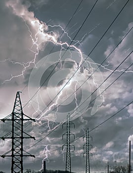 High voltage electricity power line towers against thunderstorm sky. Transmission towers