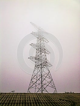 High voltage electricity pylon in the morning mist.