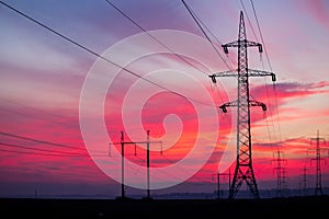 High voltage electricity pylon system on sunrise background