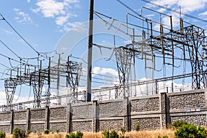 High voltage electricity towers and power lines at a transmission substation in South San Francisco Bay Area; San Jose, California