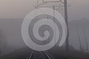 High voltage electricity transfer lines and pylon in a fog