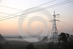 High voltage electricity transfer lines and pylon in a fog