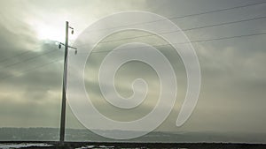 High voltage electricity transfer lines and pylon in a fog