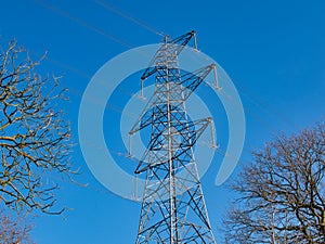 A high voltage electricity transmission pylon in winter - part of the national grid for the distribution of power