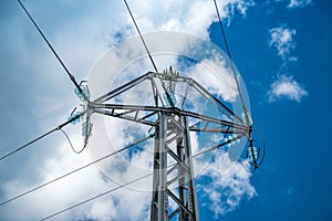 High-voltage insulated wires on glass insulators of power transmission towers against the background of blue sky and