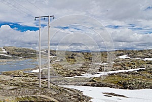 High-voltage line with wooden electric poles in the nordic mountain landscape