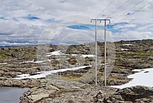 High-voltage line with wooden electric poles in the nordic mountain landscape