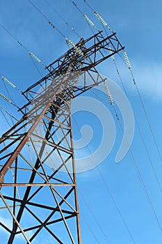 High voltage pole stands against the blue sky