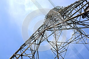 low angle view of steel framework of high voltage tower pole with electricity transmission power lines photo