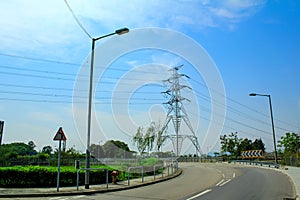A High voltage post, and electrical transmission tower with high voltage lines under the blue sky background.