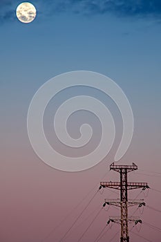 High voltage post with full moon at sunrise. Minimalism.