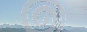 High voltage post or High voltage tower on background mountains with Wind turbines
