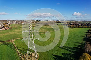 High voltage post,High voltage tower sky field grass housing esate aerial drone view