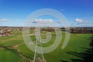 High voltage post,High voltage tower sky field grass housing esate aerial drone view