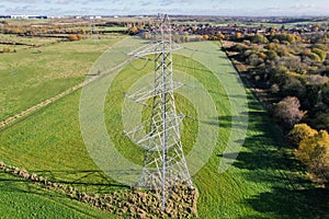 High voltage post,High voltage tower sky field grass housing esate aerial drone view