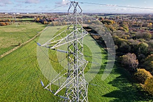 High voltage post,High voltage tower sky field grass housing esate aerial drone view