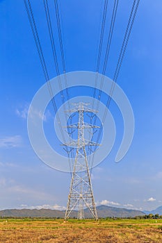 High voltage post and power lines with blue sky