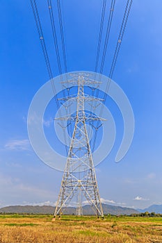 High voltage post and power lines with blue sky