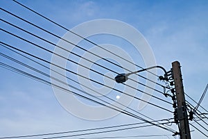 High voltage power electric wire pole with street light again moon on the sky background