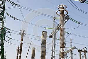 A high-voltage power electrical substation. Power lines, poles, ceramic and glass insulators, lightning arresters, sulfur