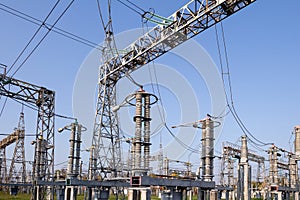 A high-voltage power electrical substation. Power lines, poles, ceramic and glass insulators, lightning arresters, sulfur