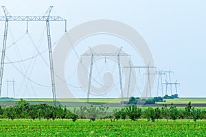 High-Voltage power line, Green Fields, Small Hills Countryside