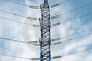 High voltage power line mast against the background of the sky. Wires and insulators