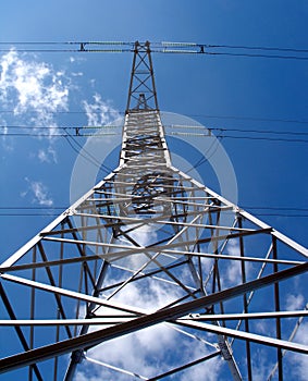 High-voltage power line metal pillar over blue sky vertical view
