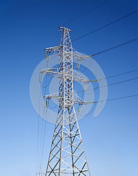 High-voltage power line metal prop over clear cloudless blue sky