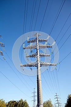 High-voltage power line metal prop over clear cloudless blue sky