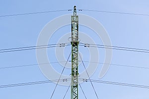 High voltage power line pole close-up. Power line mast on a blue sky background. Electrification, energy concept