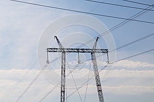 High voltage power line pole, pylon. Power line mast on a blue sky background. Electrification, energy concept