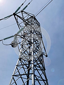 high voltage power line tower against a clear blue sky