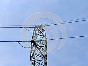 high voltage power line tower against a clear blue sky