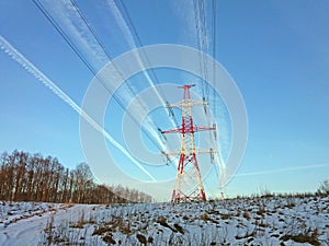 High voltage power line tower in a background of blue sky.