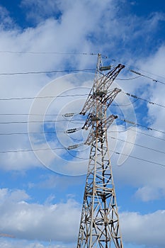 High voltage power line. View of the metal support of the power transmission line against the background of the blue sky