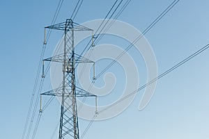 high voltage power lines against blue sky