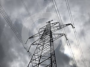 High voltage power lines on background of sky. Towers power lines against a cloudy sky background. Electricity transmission pylons