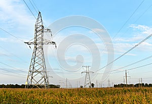 High voltage power lines on blue sky background. Electric transmission pylon tower. Wire electrical energy. Electricity concept