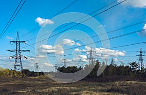 High-voltage  power lines at clouds and pine forest