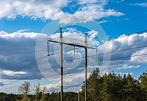 High-voltage  power lines at clouds and pine forest