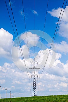 High voltage power lines and cloudy blue sky