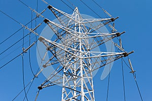 High voltage power lines in front of a blue sky